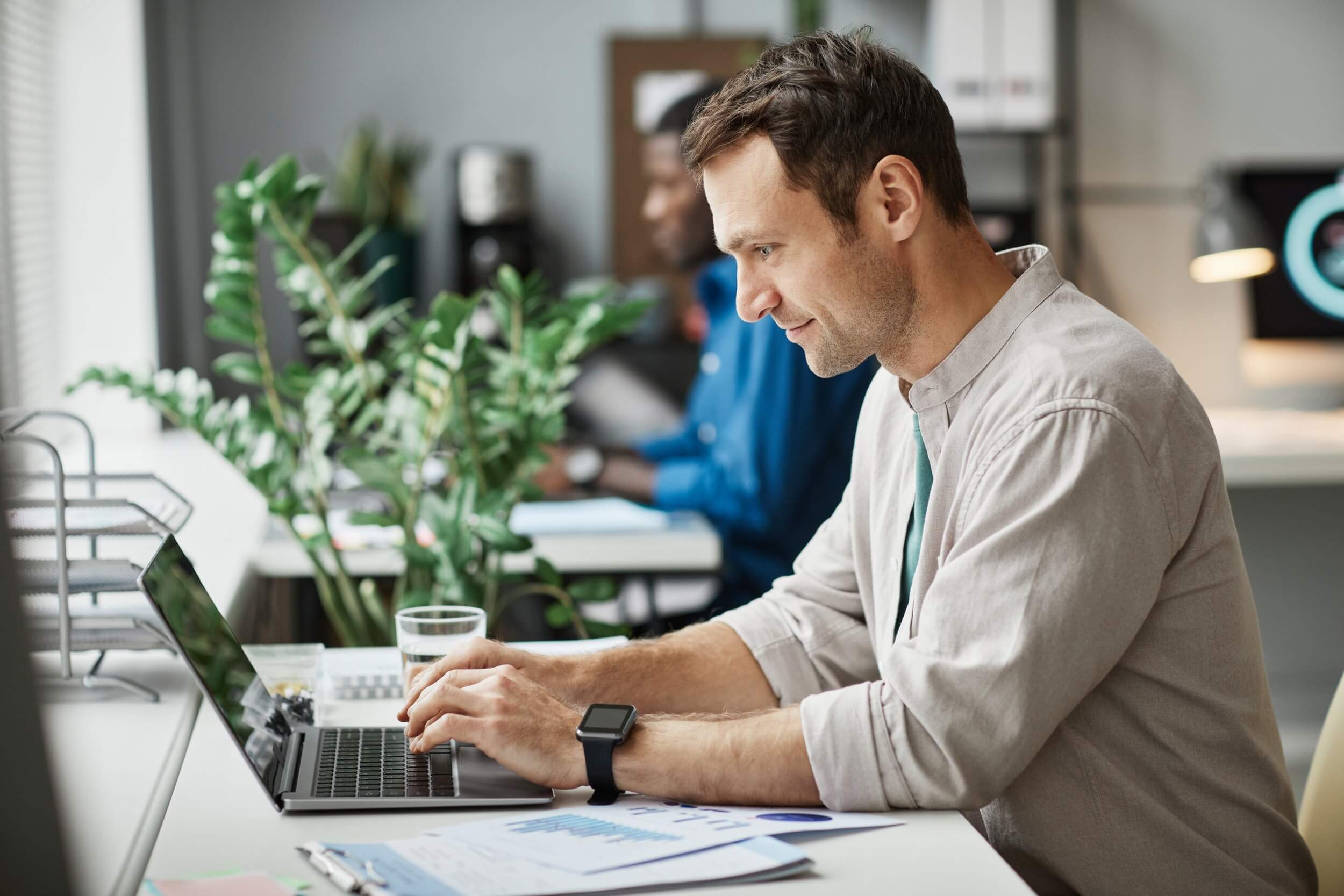 man working at computer in office side view